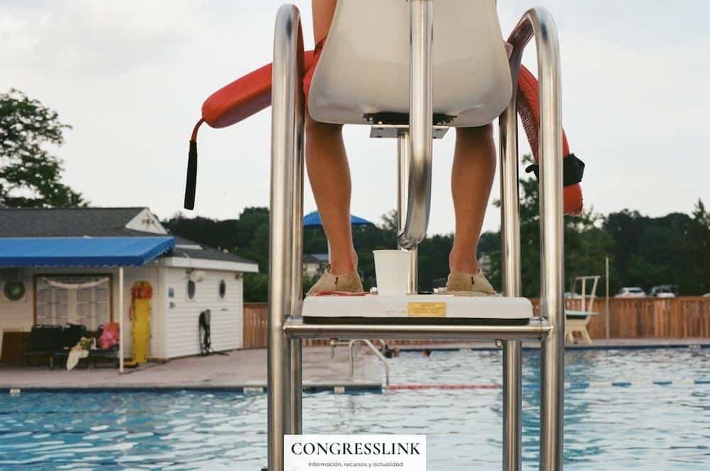 person sitting beside swimming pool during daytime