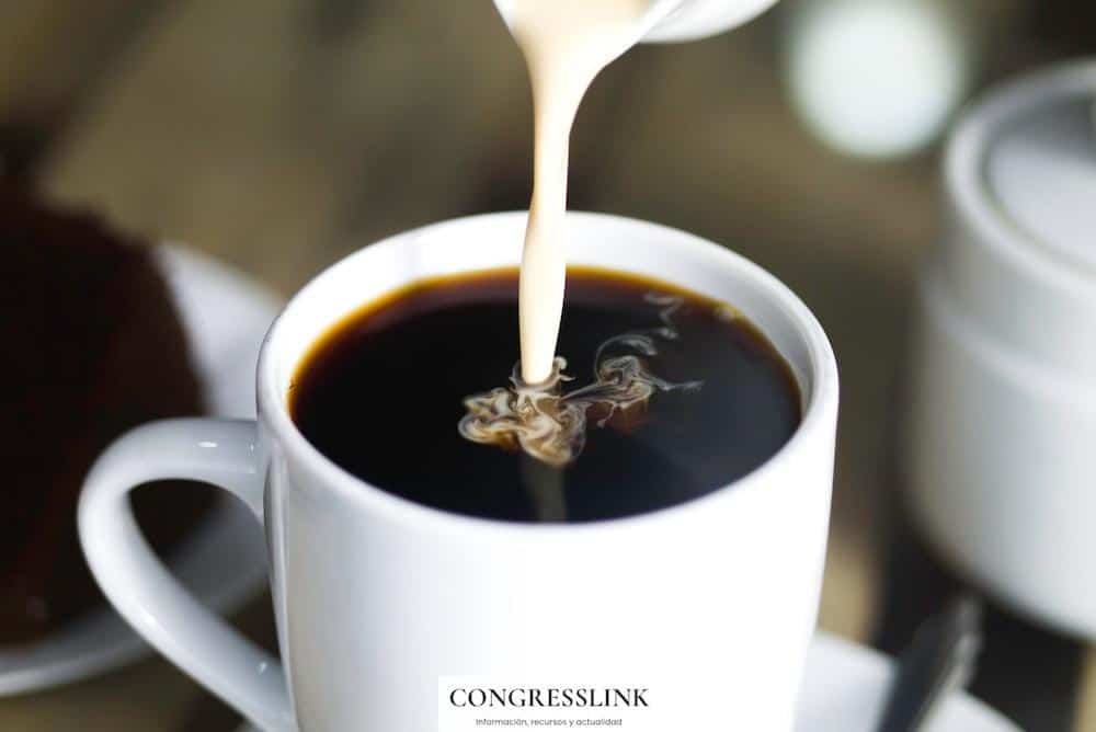 coffee in white ceramic mug while pouring milk