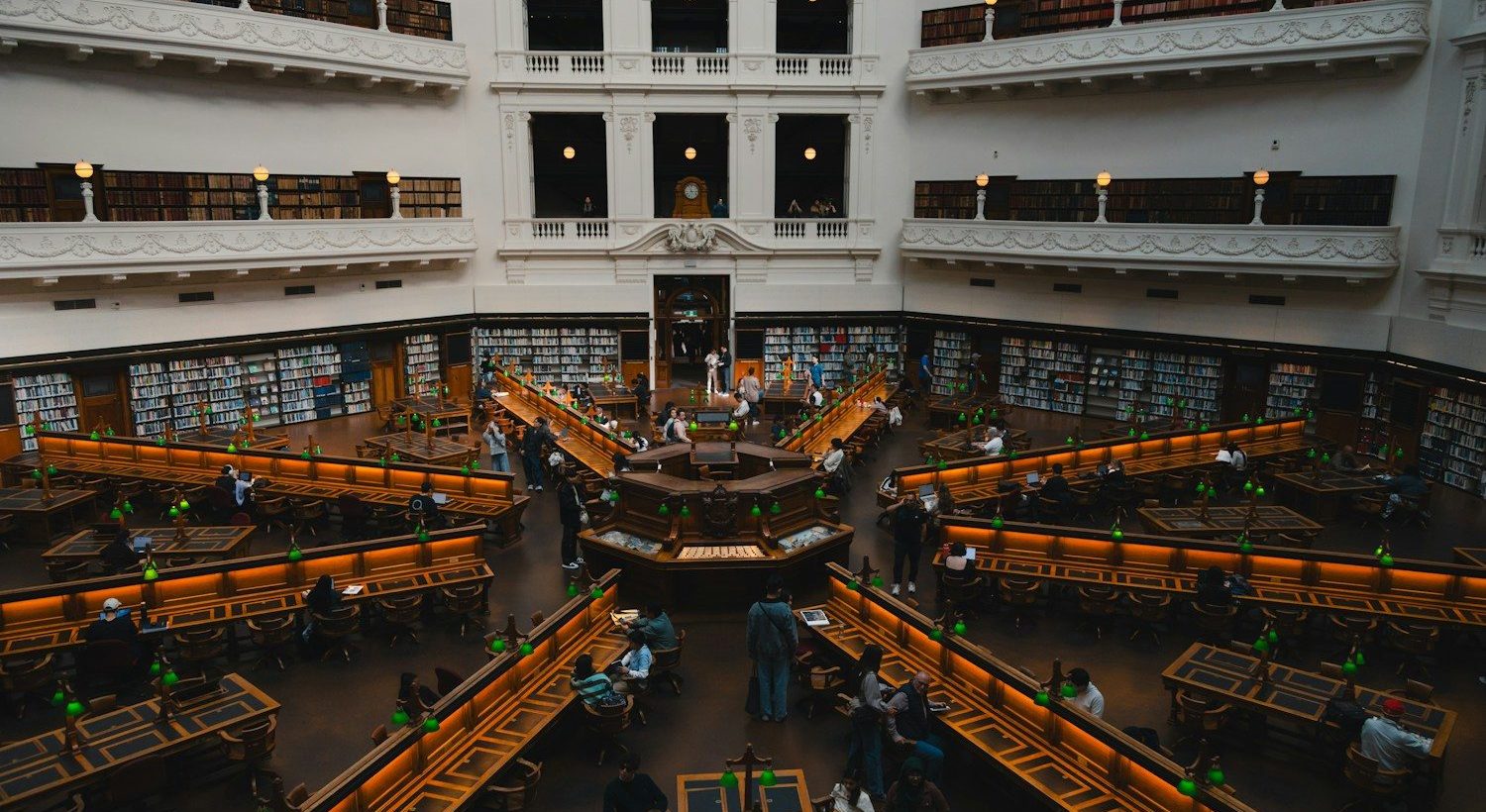 Sala de lectura de una biblioteca con mesas y lámparas